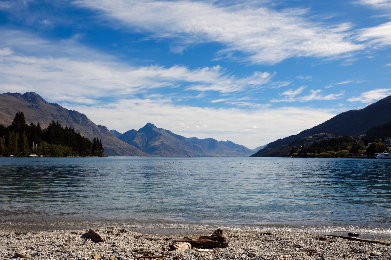 Tranquil views of Lake Wakatipu with surrounding mountains in Queenstown, New Zealand.